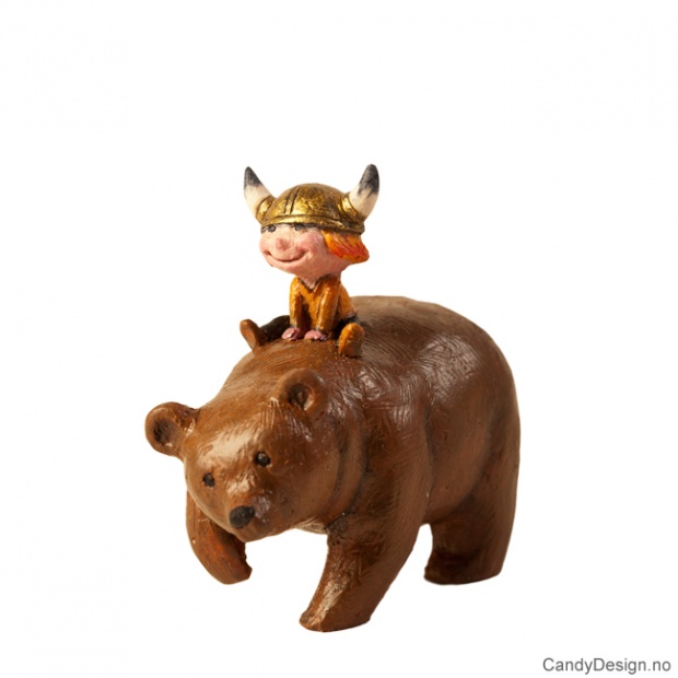 Vikingboy sitting on a brown bear souvenir